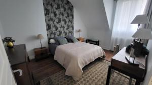 a bedroom with a bed and a wall at Maison de ville avec garage in Beaugency
