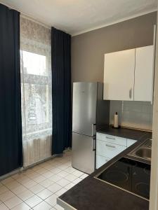 a kitchen with a stainless steel refrigerator and a window at Gemütliche Zimmer - Messe Gruga in Essen