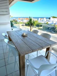 une table et des chaises en bois sur un balcon avec vue dans l'établissement Esturion de Montoya, à Punta del Este