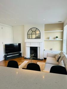 a living room with a couch and a fireplace at Stunning Flat in Chiswick in London