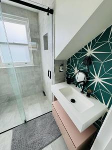 uma casa de banho com um lavatório e um chuveiro em Stunning Flat in Chiswick em Londres