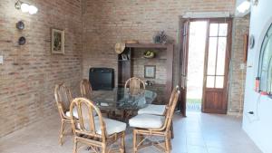 a dining room with a glass table and chairs at El Calden in Villa Ciudad de America