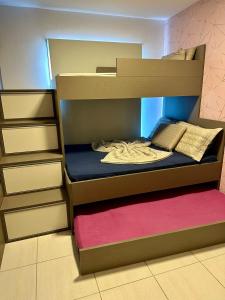 a bunk bed in a room with a pink rug at Muro Alto Clube Residence in Ipojuca