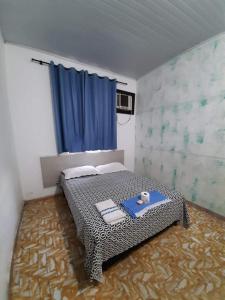 a bedroom with a bed with two towels on it at Hotel Perola Ltda in Cuiabá