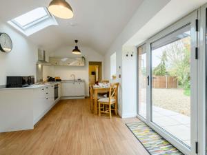 an open kitchen and dining room with a sliding glass door at 2 Bed in Aylsham 90030 in Brampton
