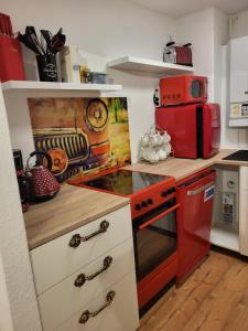 eine Küche mit einem roten Herd und einer Mikrowelle in der Unterkunft Bergblick in Königstein an der Elbe