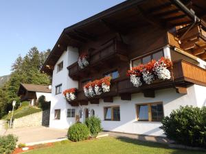 ein Gebäude mit Blumenkästen auf den Balkonen in der Unterkunft Haus Thaler in Reith im Alpbachtal