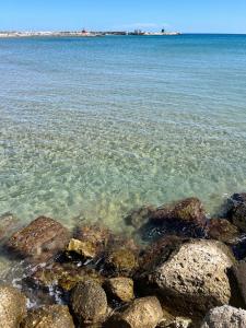 un grupo de rocas en el agua en una playa en Cielo B&b, en Crotone