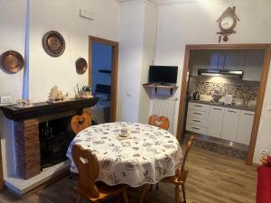 a dining room with a table and a kitchen at Appartamento Edelweiss in Fiera di Primiero