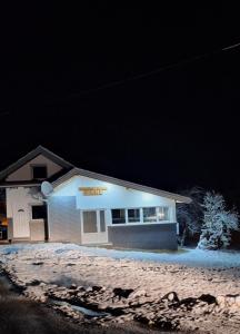 a building with a sign on it at night at Vikendica Avram-Plane 