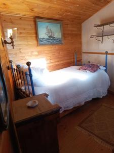 1 dormitorio con 1 cama en una habitación con paredes de madera en el portal de zapallar ,laguna de zapallar maitencillo, en Zapallar