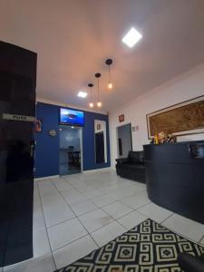 um átrio com paredes azuis e um sofá e uma televisão em Hotel Perola Ltda em Cuiabá