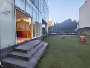 a building with a grass yard with stairs next to it at Toreo, polanco. in Mexico City