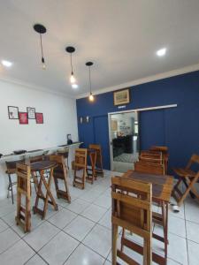 um restaurante com mesas e cadeiras de madeira e uma parede azul em Hotel Perola Ltda em Cuiabá