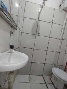 uma casa de banho com um lavatório e um WC em Hotel Perola Ltda em Cuiabá