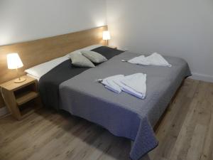 a bedroom with a bed with two white towels on it at Hotel Forea in Lanškroun