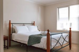 Schlafzimmer mit einem Bett mit weißer Bettwäsche und einem Fenster in der Unterkunft Mara House - Space for Everyone in St Helens