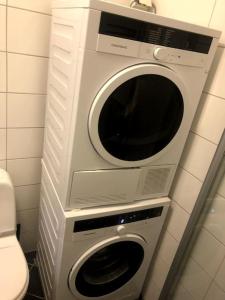 two washing machines stacked on top of each other in a bathroom at Fin og super sentral leilighet in Bergen