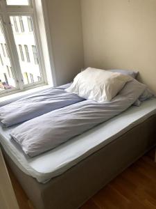 - un lit sans matelas avec un oreiller et une fenêtre dans l'établissement Fin og super sentral leilighet, à Bergen