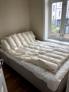 - un lit non aménagé dans une chambre avec fenêtre dans l'établissement Fin og super sentral leilighet, à Bergen