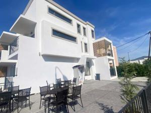 a white building with tables and chairs in front of it at Zeus Potos in Potos