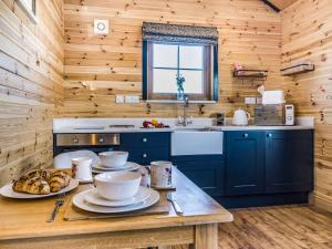 a kitchen with wooden walls and a table with food on it at 1 Bed in Rhayader 90285 in Saint Harmon