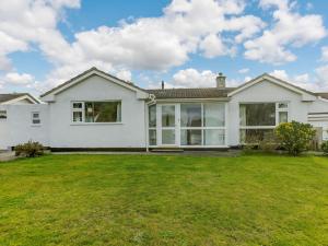 a white house with large windows and a yard at 2 Bed in Bude 90312 in Bude