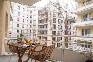 een balkon met een tafel en stoelen en een gebouw bij Le Bord de Seine 5min à pieds Gare/Parking Gratuit in Rueil-Malmaison