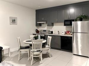 a kitchen with a table and a stainless steel refrigerator at Blissful Stay in Surrey in Surrey