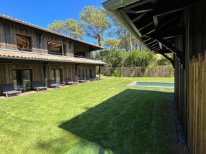 a large yard with chairs and a house at la Villa des Cap - à 400m Océan et Bassin in Cap-Ferret