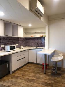 a kitchen with white cabinets and a table in it at Rajhans belliza 2bhk Flats in Surat