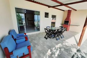sala de estar con sofá azul, mesa y sillas en Frente ao mar casa 42 Praia do Estaleiro en Ubatuba