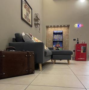 uma sala de estar com um sofá e uma mala em Senza Pressa b&b em Portici