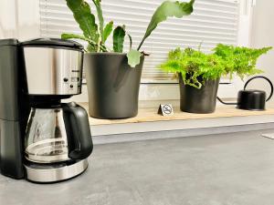 a coffee maker on a counter with potted plants at Apartment LEO in Berghausen