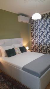 een groot wit bed in een kamer met een muur bij Slivnitsa 105 in Varna