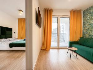 a room with a bed and a green couch at Wygodne Mieszkania Nova Mikołowska 123 in Katowice