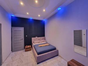 a bedroom with a bed and a mirror at Résidence Schilo - appartement équipé avec piscine privée et rooftop in Abomey-Calavi +45 photos