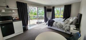 a bedroom with a bed and a view of a balcony at Woodbury Farm B&B in Takanini