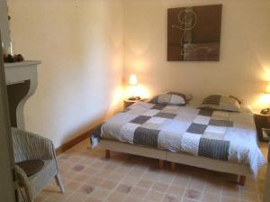 a bedroom with a bed with a checkered blanket at Le Cercotin in Moroges