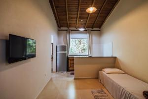 ein Wohnzimmer mit einem TV und einem Kühlschrank in der Unterkunft Chales do Ademir in Ilhabela