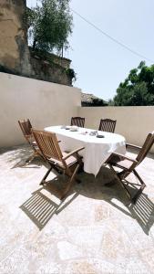 een tafel met vier stoelen en een wit tafelkleed bij Luxury Villa Prada in Skriperón