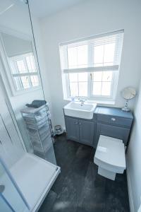 bagno con lavandino, servizi igienici e specchio di Large luxury apartment in the heart of Bakewell a Bakewell