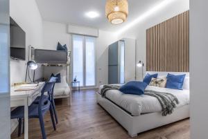 a bedroom with a desk and a bed with blue pillows at StayEasy Quadronno33 - 3 bedrooms, 2 baths - Duomo walking distance in Milan