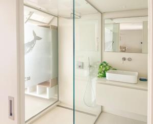 a bathroom with a shower with a sink and a mirror at Radazul Seafront Marina 9 in Radazul