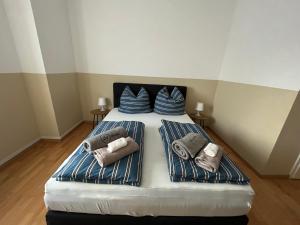 uma cama com duas almofadas e toalhas em Zimmer- Pension-Gästehaus em Meine