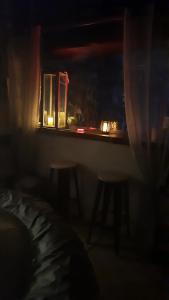 a dark room with a table and two stools and a window at chambre love romantique avec spa privée in Calvi