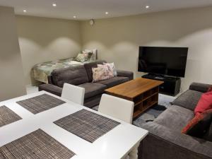 uma sala de estar com um sofá e uma mesa em 90 m2 charmig källarlägenhet nära natur och stad em Mölndal