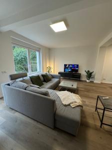 a living room with a couch and a tv at Haus mit Garten - Kingbett - WIFI - Parkplatz in Essen