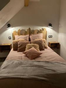 ein Schlafzimmer mit einem großen Bett mit Kissen darauf in der Unterkunft Als AS DE COEUR La maison aux mille et un coeurs in Neuve-Église