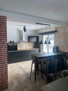 eine Küche mit einem großen Tisch in einem Zimmer in der Unterkunft Als AS DE COEUR La maison aux mille et un coeurs in Neuve-Église